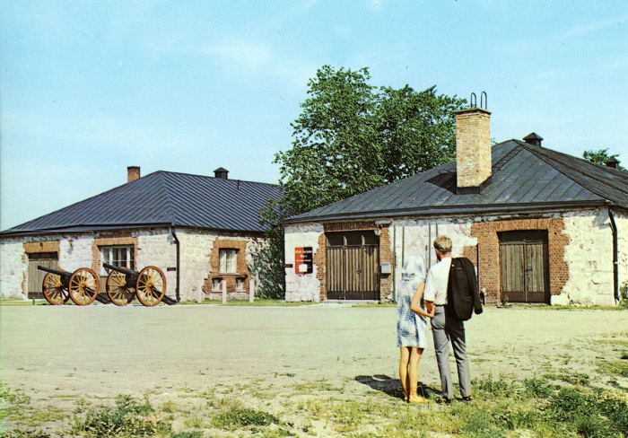 Etelä-Karjalan museon rakennukset; mies ja nainen katsovat museorakennuksia, kaksi tykkiä. Kuva ajoittuu vuosille 1968-1969.